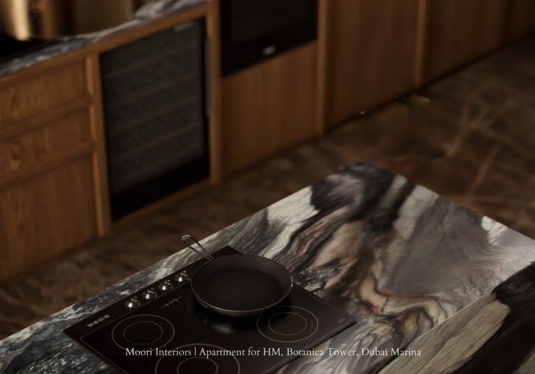 Modern kitchen island with marble top, induction cooktop, and pan. Wood cabinets in background.