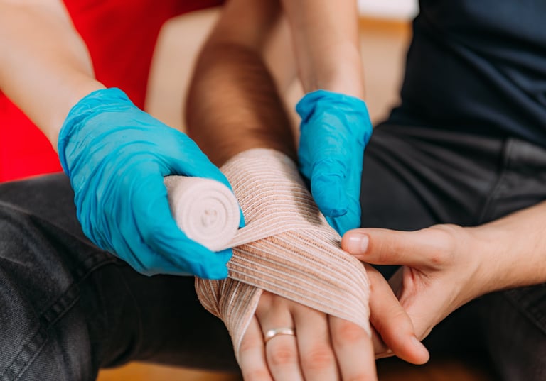 Close up image of a person bandaging someone's hand