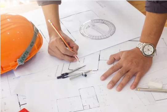 a person holding a pencil and a ruler