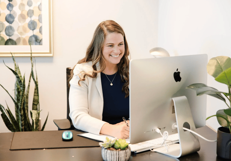 A picture of Lindsay smiling while on a video call with a client.