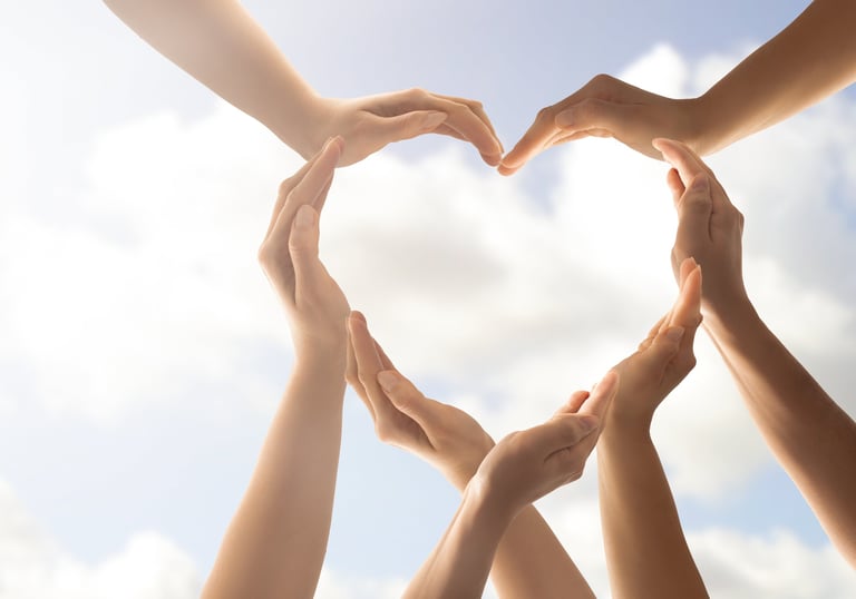 a group of people holding hands in a heart shape