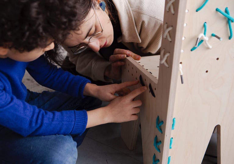 a woman is holding a wooden toy and a child's hand