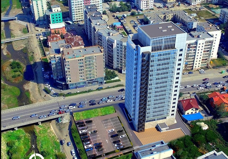 a city street scene with a large building in the background