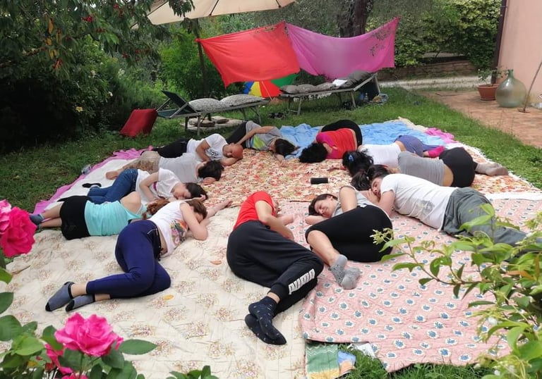 a group of people sitting on a blanket on a blanket, rilassamento, classe bioenergetica