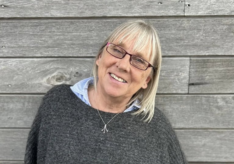 a woman in a gray sweater and glasses