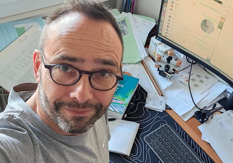 a man wearing glasses works on his computer