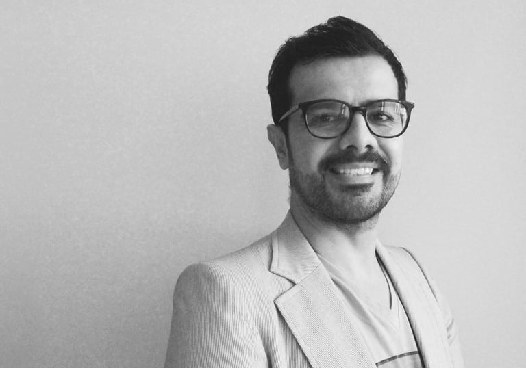 a man in a suit and glasses smiling