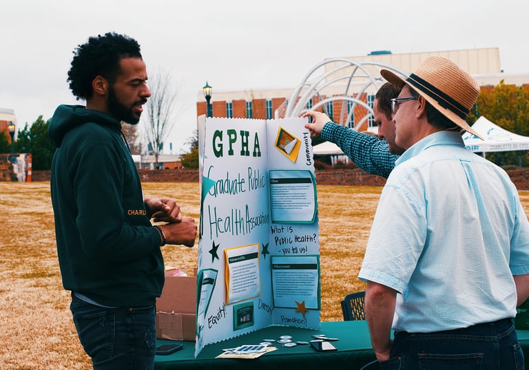 People at UNC Charlotte conversing at the Graduate Public Health Association stall at the Earth Day Festival.