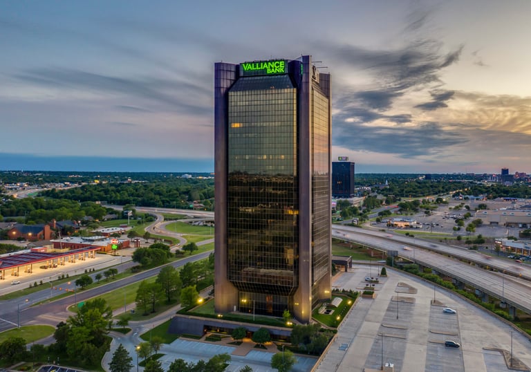 The Valliance Bank tower standing tall in the Oklahoma City skyline during a sunset aerial view.