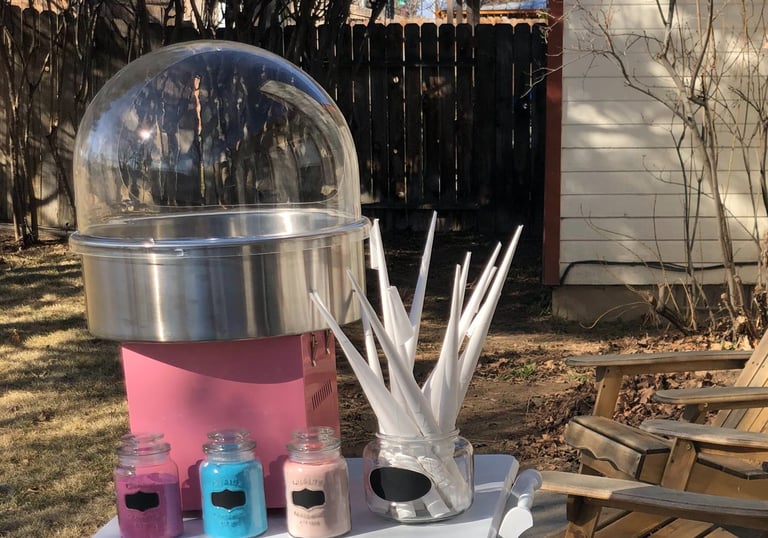 a pink cotton candy machine with a clear dome and three containers of flavored sugar