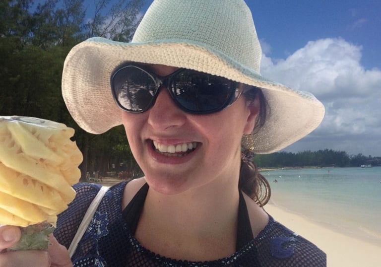 Autora saboreando abacaxi esculpido na praia de Mont Choisy, Port Louis, Ilhas Maurício.