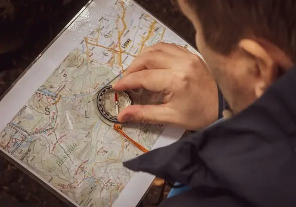 Candidat préparant le probatoire AMM en orientation avec carte et boussole en montagne