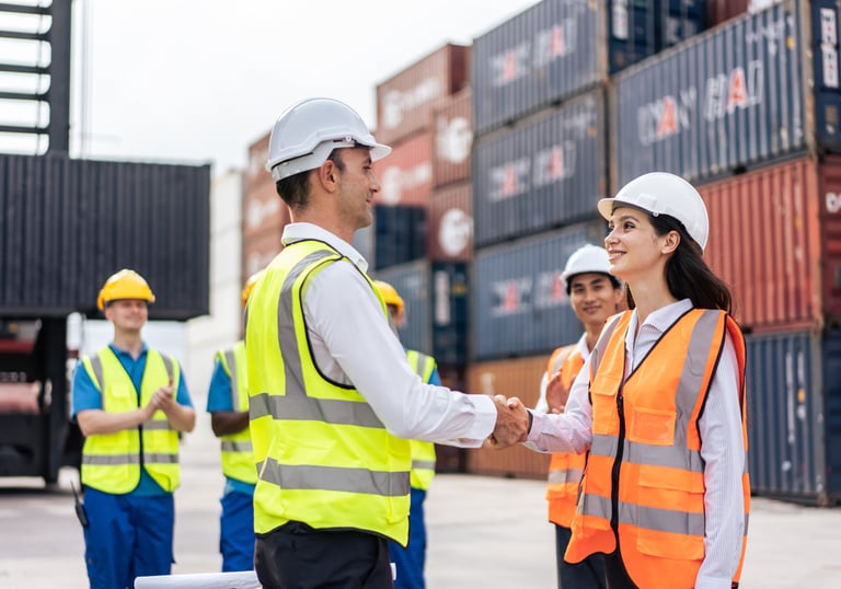 a man and woman shaking hands in front of a container container