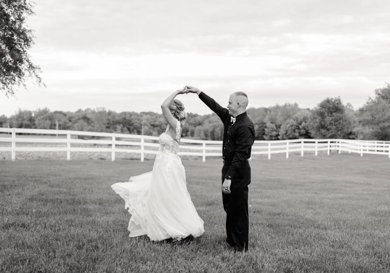 a bride and groom dancing in a field