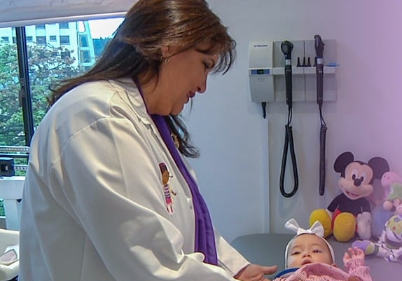 a woman in a white lab coat and a teddy bear