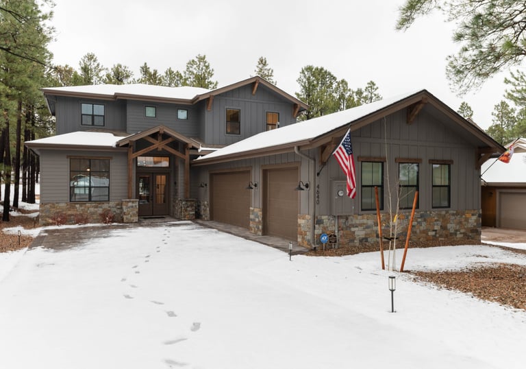 custom home with large garage and snowy driveway