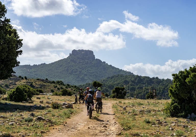 Cyclists exploring the landscapes of Urzulei, Sardinia, along rural paths