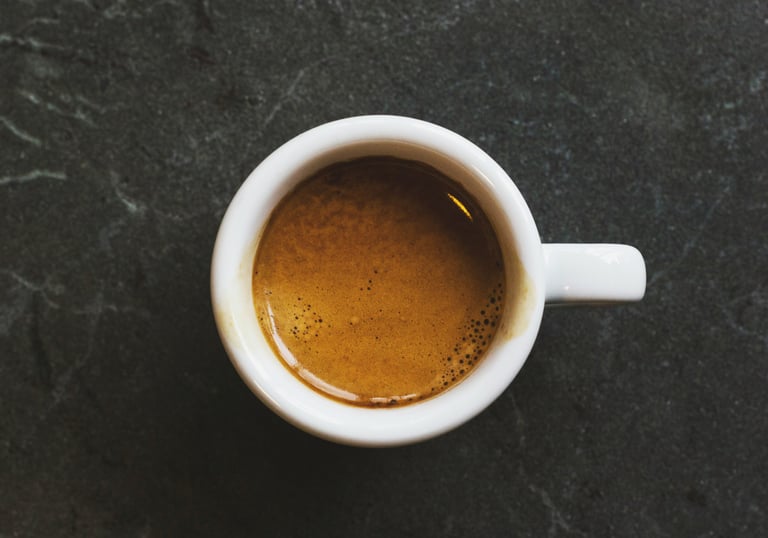 An espresso cup on top of a grey table