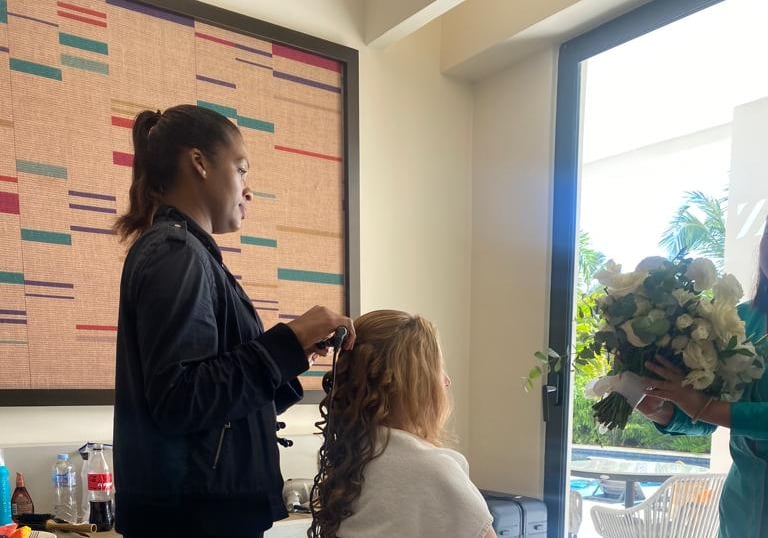 Deya Ventura bridal hair stylist curling a bride’s hair during wedding day preparations in Punta Cana, Dominican Republic