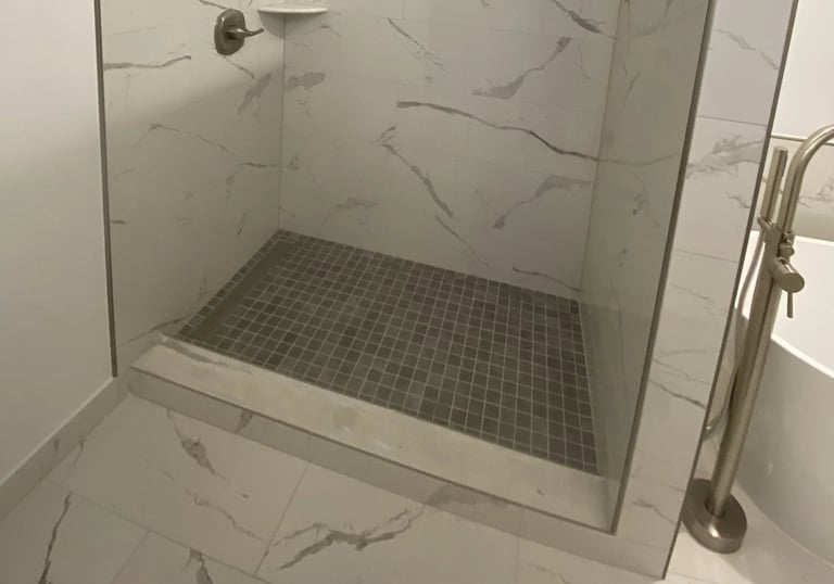 Contemporary walk-in shower with marble-look tiles and brushed nickel fixtures