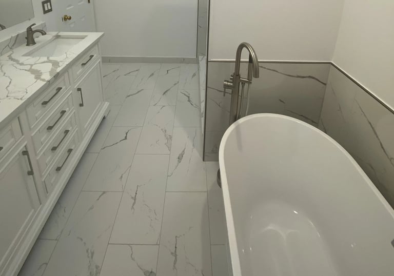 Contemporary bathroom with vanity and freestanding bathtub with marble tiles