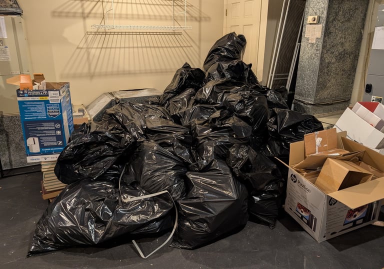pile of trash bags and cardboard boxes