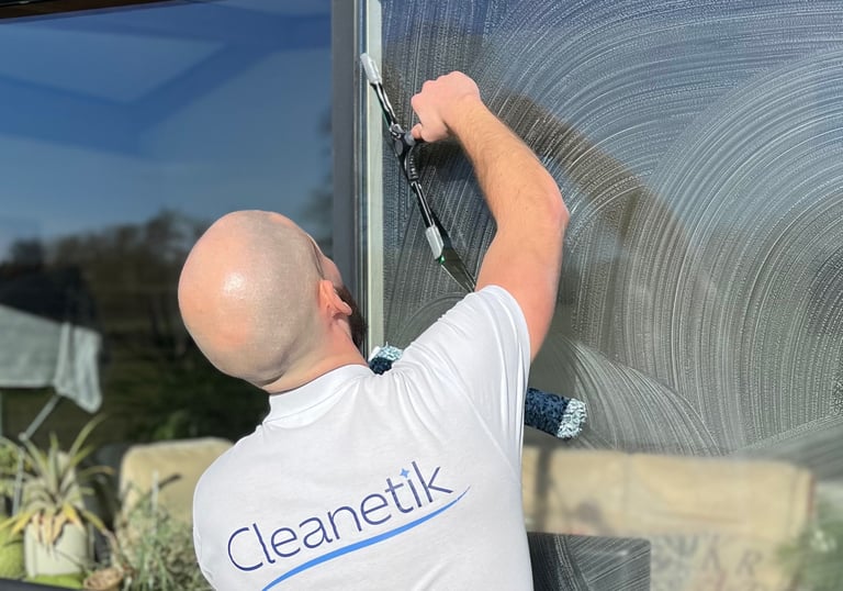 a man in a white shirt is cleaning a window