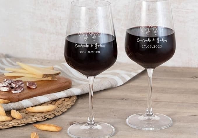 two wine glasses with wine glasses on a table