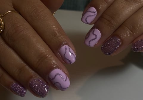 a woman's hands with a purple manicured manicured manicure