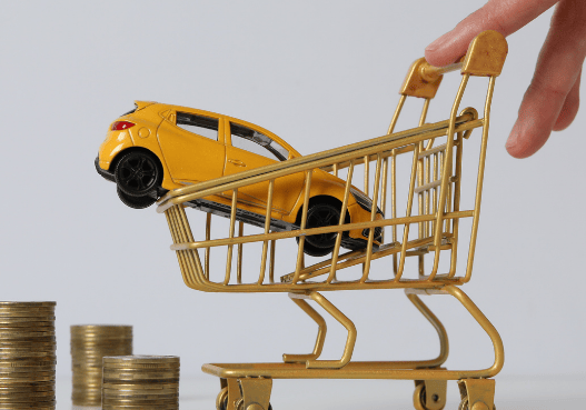 Coche en carrito de compras manejado por una mujer y monedas a un lado