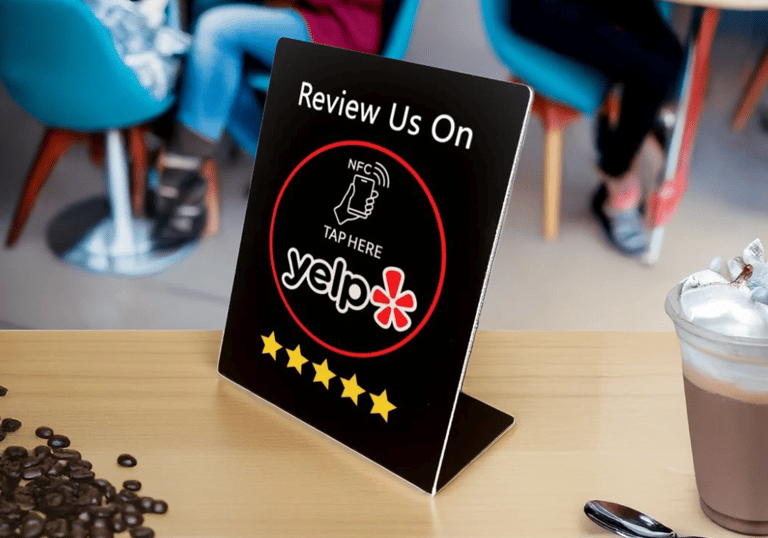 Yelp NFC review sign on cafe counter with coffee and beans. Boost feedback using digital tech.