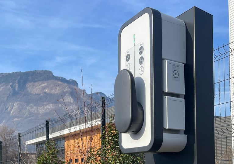 a parking meter with a car parked in front of a fence