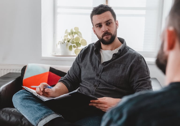 Ein Berater hört seinem Klienten aufmerksam zu und macht sich Notizen