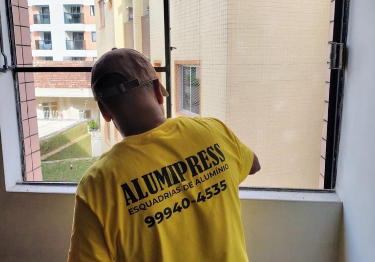 a man in a yellow shirt is looking out the window