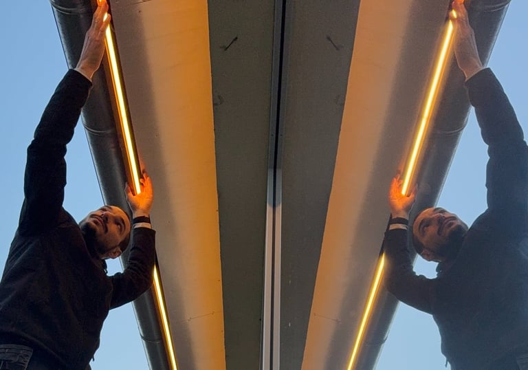 two men standing on a ladder ladder to reach up to the top of a building