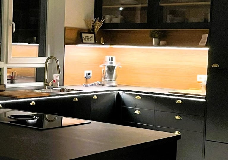 a kitchen with a black counter top and a kitchen island