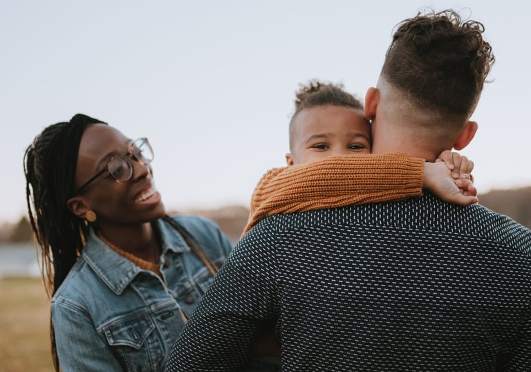Family in field smiling with child