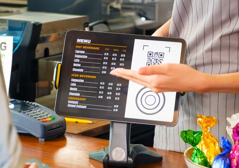 Tablet POS screen showing menu and QR code on café counter. Turn tablets into kiosk menus.