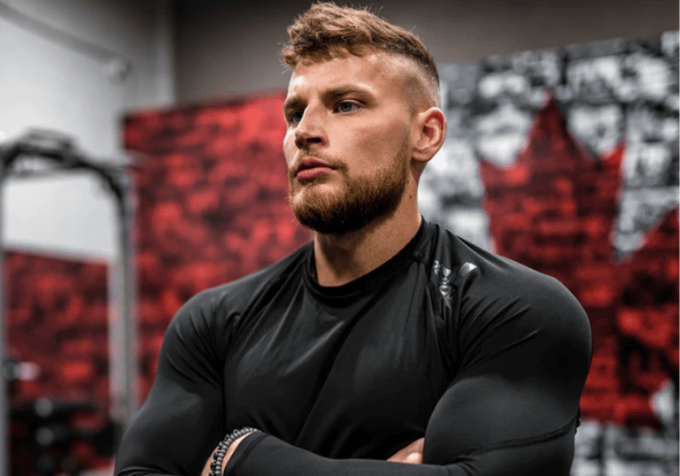 a man with a beard and a beard, standing in a gym