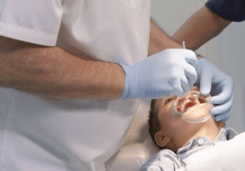 a man in a white shirt is getting ready to be a dentist