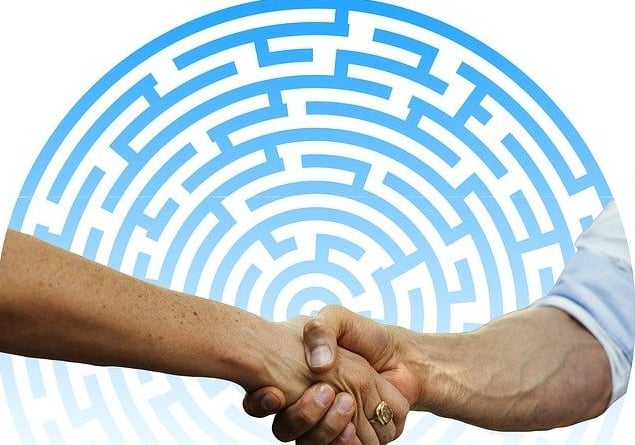 Händeschütteln vor Labyrinth – Visualisierung für Konfliktlösung und Klarheit