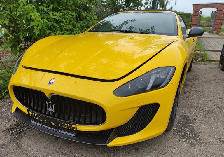 an Enlab yellow Maserati sports car parked in a driveway
