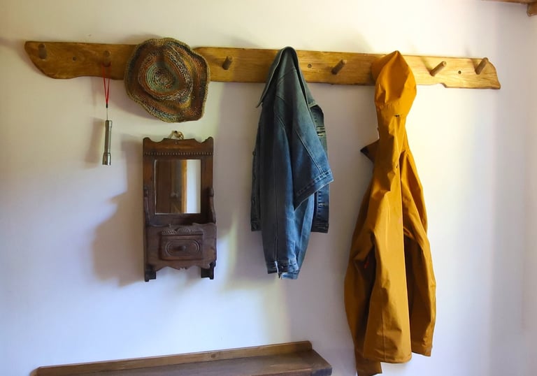 Holiday rental coat rack with jackets, a hat and a pair of boots