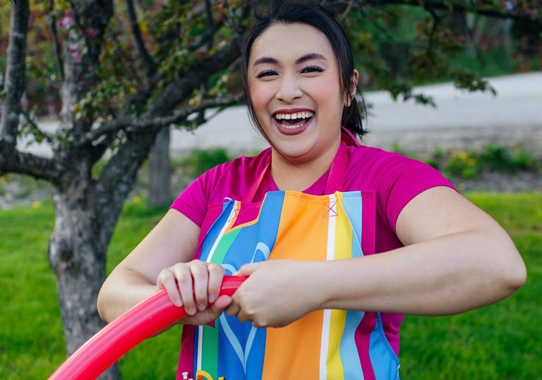 A balloon twister smiling for a photo