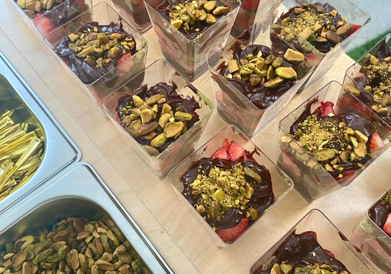 a table with chocolate Dubai strawberry cups desserts on it