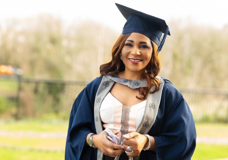 Smiling Black woman in a graduation cap and gown graduation photography Liverpool