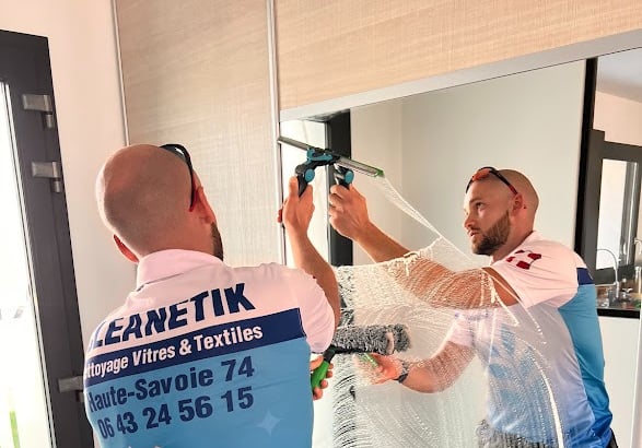 a man in a blue shirt cleaning mirror