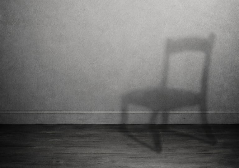 Minimalist black and white image of a chair casting a shadow