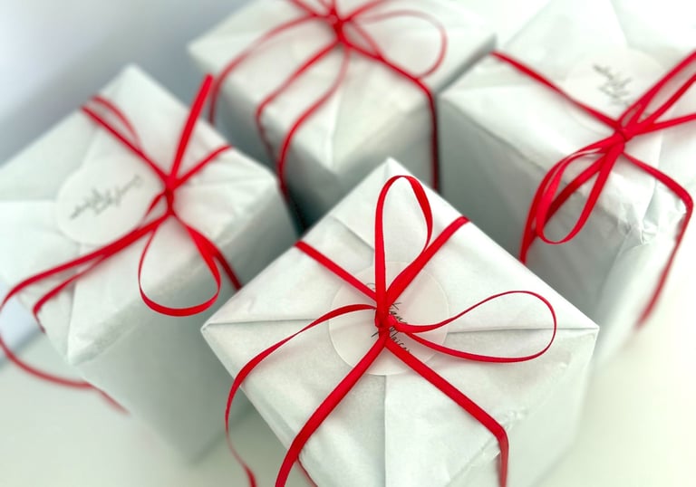 a bunch of white boxes with red ribbon tied to them