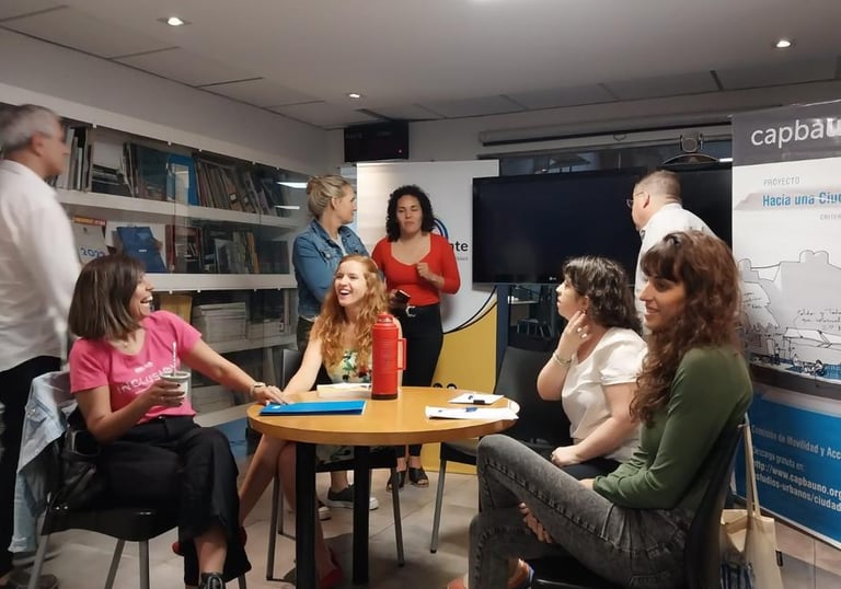 Personas conversando y compartiendo mate en una reunión sobre accesibilidad en un espacio institucio